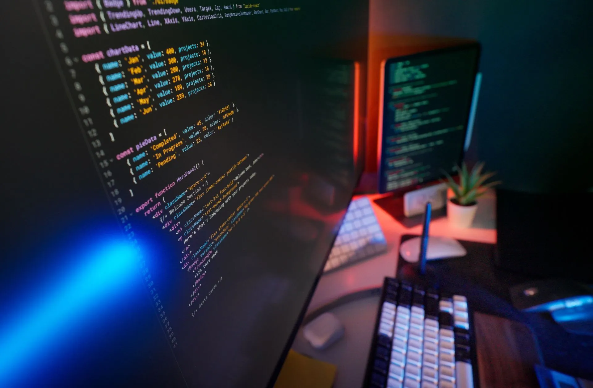Escritorio con monitores y un teclado iluminado
