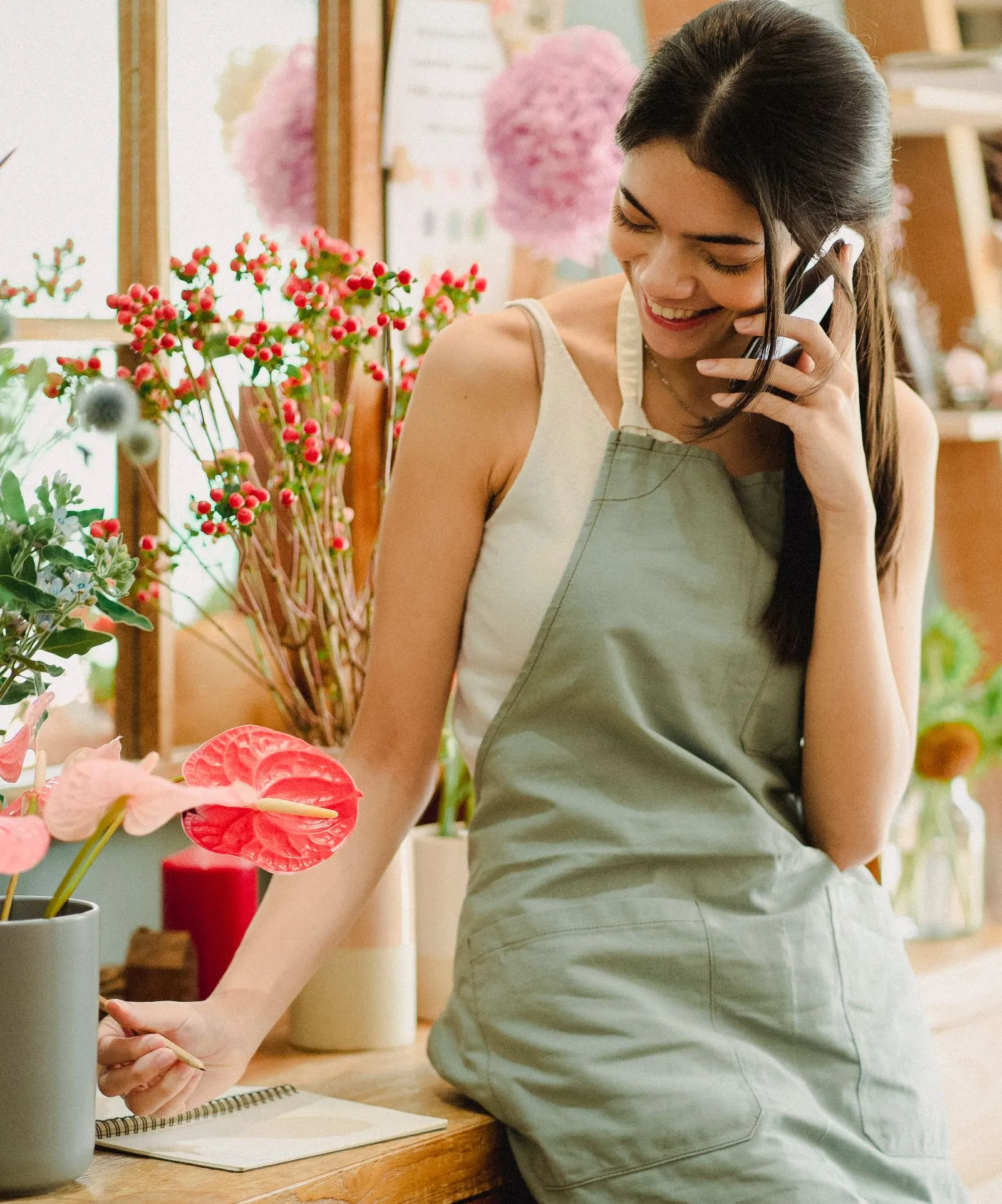 Florista atendiendo un pedido por teléfono en su tienda