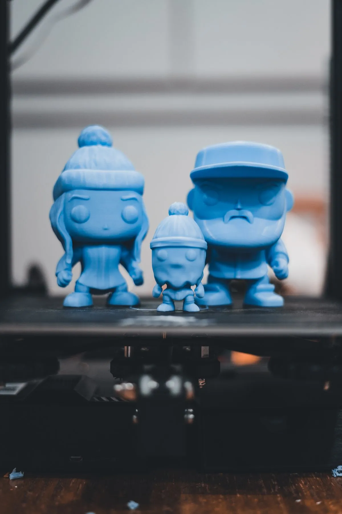 Figuras azules impresas en 3D sobre la cama de una impresora