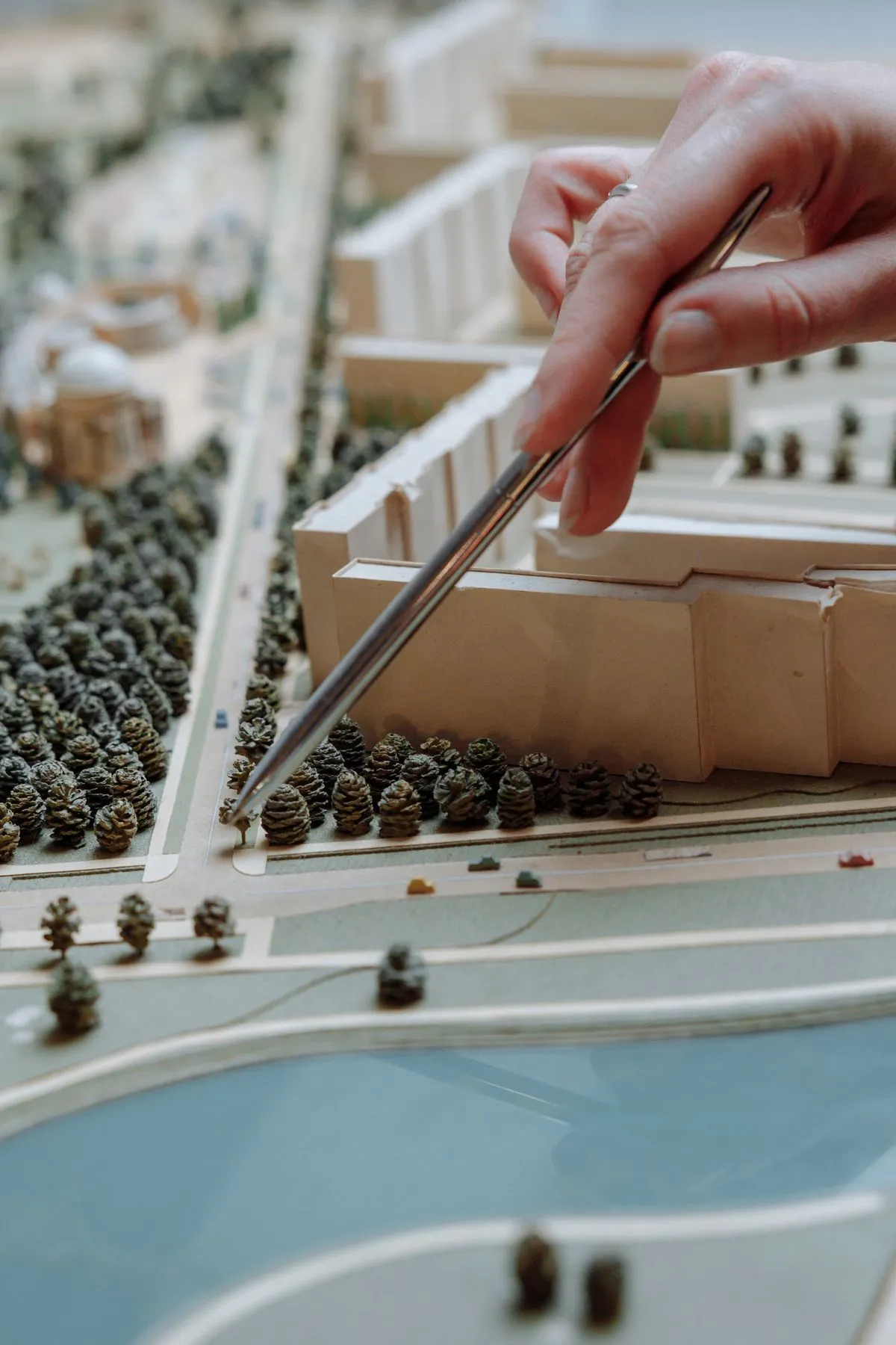 Mano ajustando una maqueta arquitectónica blanca